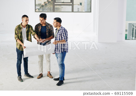 Engineer showing building blueprint 69115509