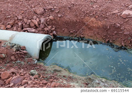 Concrete circular run-off pipe discharging water. sewage pipe polluting the river. 69115544