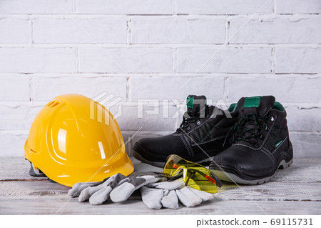 A helmet and safety shoes are essential personal accessories for every employee in the profession of a builder. 69115731