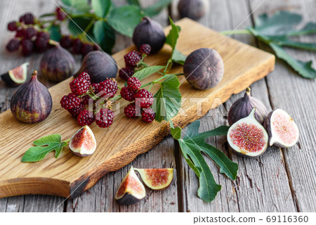 Fresh juicy figs and blackberries on a dark background 69116360