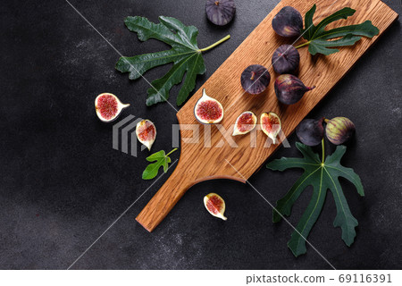 Fresh ripe figs on a dark concrete background. Harvesting figs Fresh ripe figs on a dark concrete background. Harvesting figs 69116391