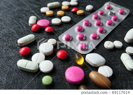 close up of white pills spilling on black background close up of white pills spilling on black background 69117014