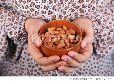 close up women hand holding a bowl on almond close up women hand holding a bowl on almond 69117062