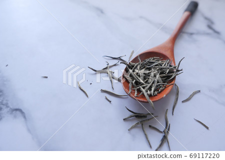Dry tea leaves on spoon close up . Dry tea leaves on spoon close up . 69117220