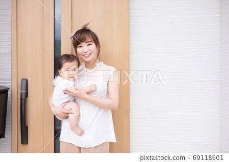 抱著一個嬰兒在我家門口的年輕女子 抱著一個嬰兒在我家門口的年輕女子 69118601