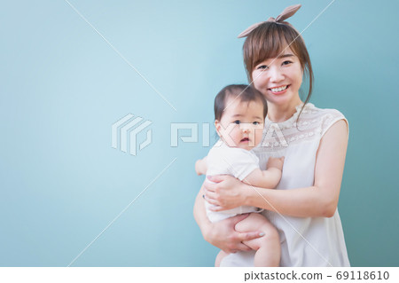 Smiling young mom holding a baby Smiling young mom holding a baby 69118610
