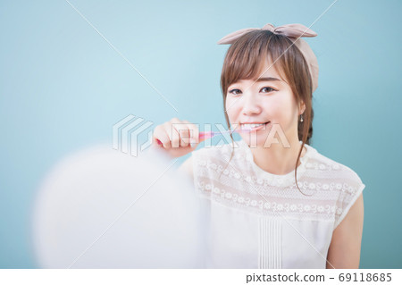 Young woman brushing teeth to prevent tooth decay Young woman brushing teeth to prevent tooth decay 69118685