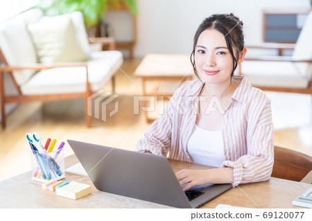 Young woman doing telework in the living room Young woman doing telework in the living room 69120077