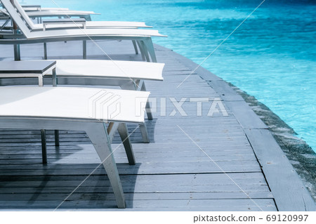 Many white chaise lounge by the pool Many white chaise lounge by the pool 69120997