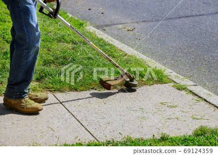 A municipal worker in an lawn mower mows fresh, 69124359