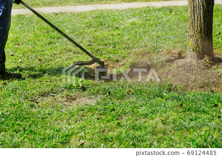 A municipal worker in an lawn mower mows fresh, A municipal worker in an lawn mower mows fresh, 69124485