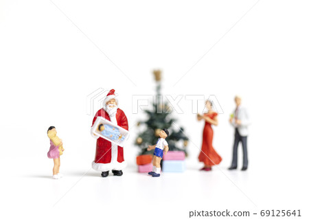 Miniature people : Santa Claus holding gift for happy family , Christmas and Happy New Year concept. Miniature people : Santa Claus holding gift for happy family , Christmas and Happy New Year concept. 69125641