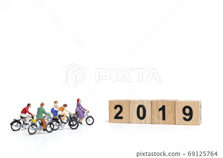 Miniature people : Friend Group ride bicycle with wooden number 2019 , Happy New Year concept. Miniature people : Friend Group ride bicycle with wooden number 2019 , Happy New Year concept. 69125764