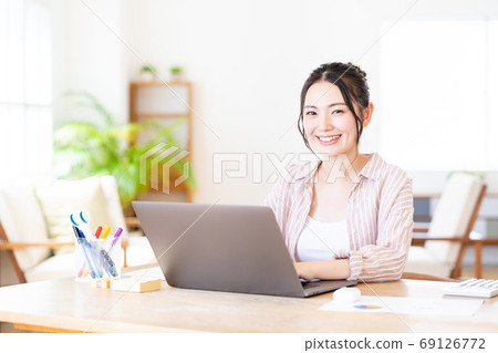 Young woman doing telework in the living room Young woman doing telework in the living room 69126772