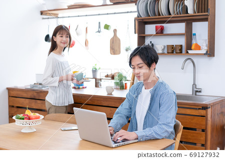 遠程工作的丈夫與妻子和妻子泡茶在計算機上工作 遠程工作的丈夫與妻子和妻子泡茶在計算機上工作 69127932