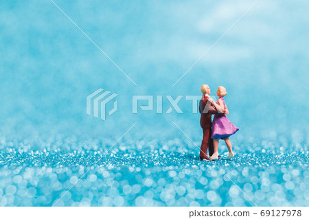 Miniature people , Couple dancing on blue glitter background 69127978