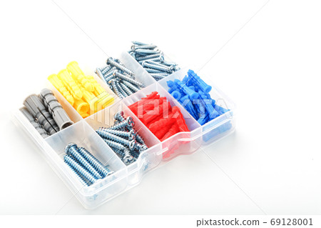 Screws and dowels of various sizes, types and colors in a transparent plastic box. 69128001