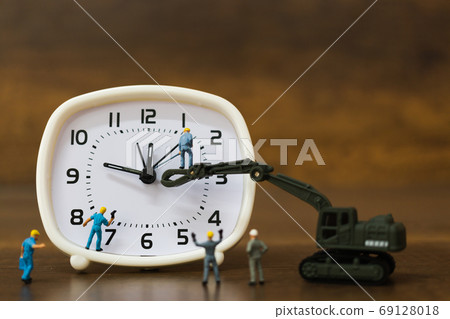 Miniature people : The team is working on an alarm clocks , working time concept Miniature people : The team is working on an alarm clocks , working time concept 69128018