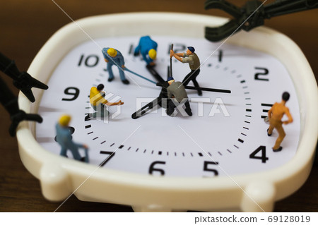 Miniature people : The team is working on an alarm clocks , working time concept Miniature people : The team is working on an alarm clocks , working time concept 69128019