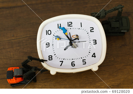 Miniature people : The team is working on an alarm clocks , working time concept Miniature people : The team is working on an alarm clocks , working time concept 69128020