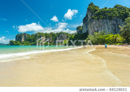 Railay Beach West. Cliffs covered with jungles and clear water during a beautiful sunny day in July (low season). Krabi, Thailand Railay Beach West. Cliffs covered with jungles and clear water during a beautiful sunny day in July (low season). Krabi, Thailand 69129031