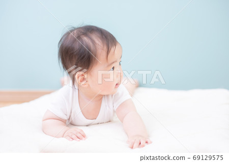Smiling baby lying prone Smiling baby lying prone 69129575