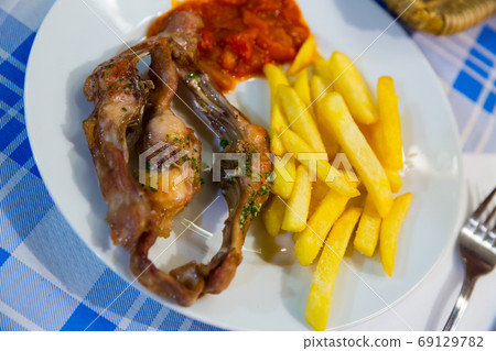 Baked rabbit pieces with vegetables Baked rabbit pieces with vegetables 69129782