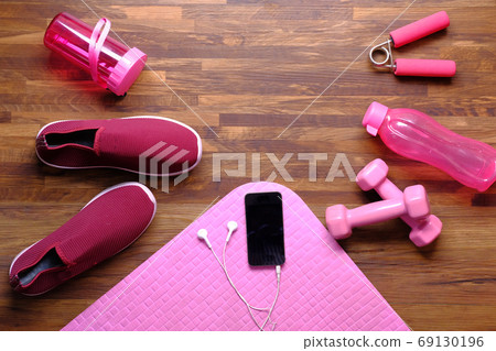 Smart phone with sports equipment on wooden floor. Smart phone with sports equipment on wooden floor. 69130196