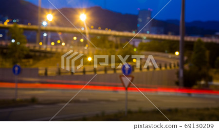 Blurred view of illuminated city road in evening Blurred view of illuminated city road in evening 69130209