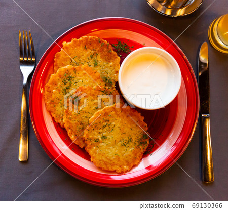 Belarusian traditional potato pancakes with sour cream 69130366