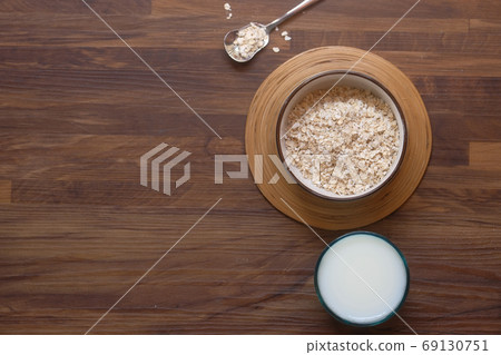 uncooked oats flakes wooden background, top down  69130751