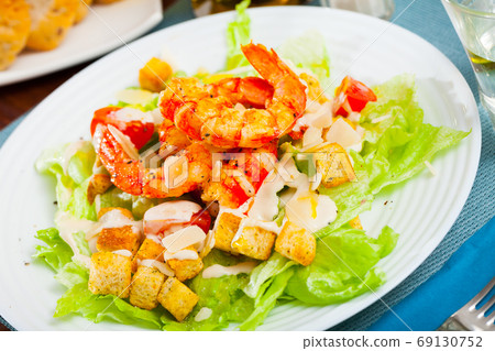Caesar salad with prawns, lettuce, sauce and cheese 69130752