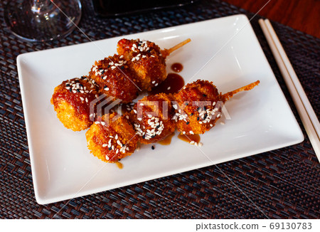 Appetizing balls of chicken with sesame seeds in spicy sauce. Japanese cuisine 69130783