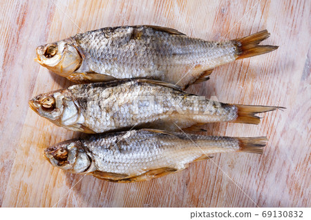 Dried salted fish on wooden background Dried salted fish on wooden background 69130832