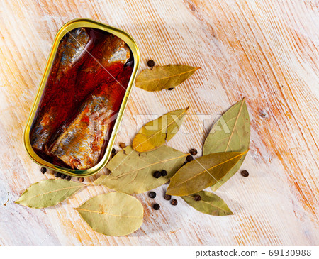 Canned sea fish, mackerel fillets in tomato served with peppers and bay leaf 69130988