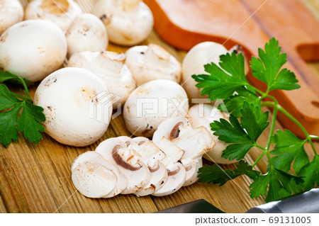 Raw champignons on wooden table Raw champignons on wooden table 69131005