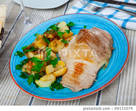 Roasted pork chop with grilled potatoes garnish 69131074