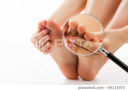 A woman who touches the magnifying glass and sole. 69131973