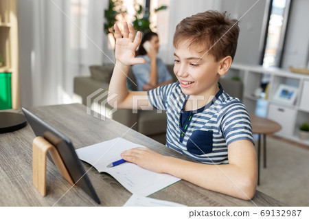 boy having video calll on tablet pc at home boy having video calll on tablet pc at home 69132987