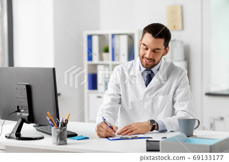 smiling male doctor with clipboard at hospital 69133177