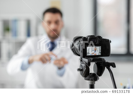 doctor with hand sanitizer recording video blog 69133178