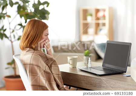 sick woman having video call on laptop at home 69133180
