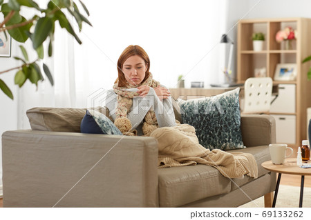 sick woman measuring temperature by thermometer sick woman measuring temperature by thermometer 69133262