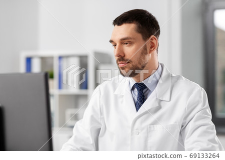 male doctor with computer working at hospital male doctor with computer working at hospital 69133264