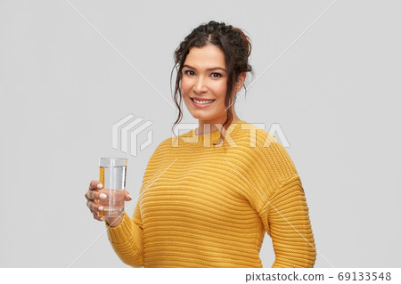 smiling young woman with water in glass smiling young woman with water in glass 69133548