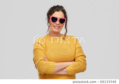 smiling young woman in heart-shaped sunglasses smiling young woman in heart-shaped sunglasses 69133549