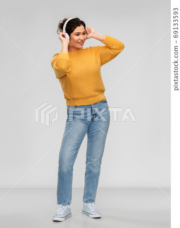 happy woman in headphones listening to music happy woman in headphones listening to music 69133593
