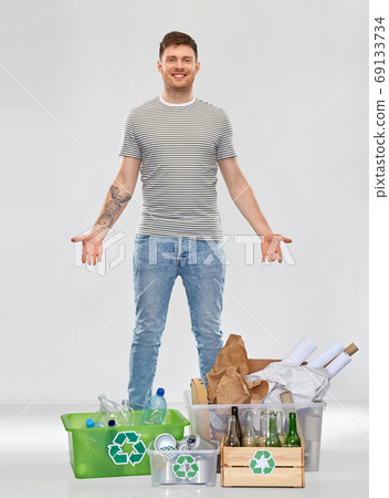 smiling man sorting paper, metal and plastic waste smiling man sorting paper, metal and plastic waste 69133734
