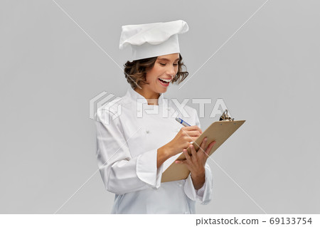 smiling female chef in toque with clipboard 69133754