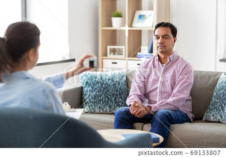 man and psychologist at psychotherapy session 69133807